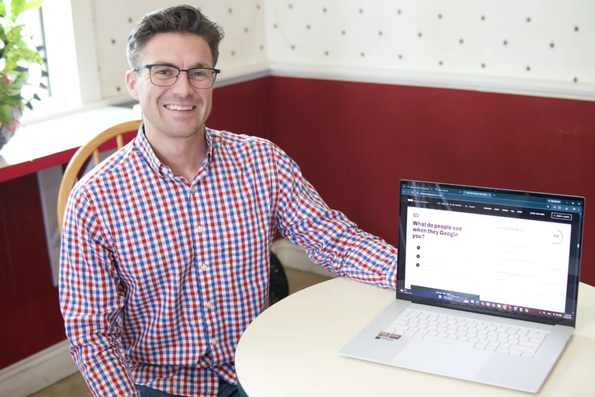 Blake Porterfield at a table, beside a laptop showing the free online audit.