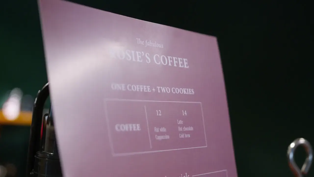 The first shot of an example commercial: a cafe menu on a stand that reads Rosie’s Coffee.